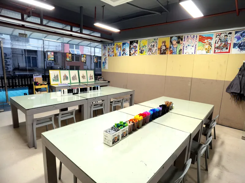 少儿美术教室实景：长桌画材与作品陈列墙